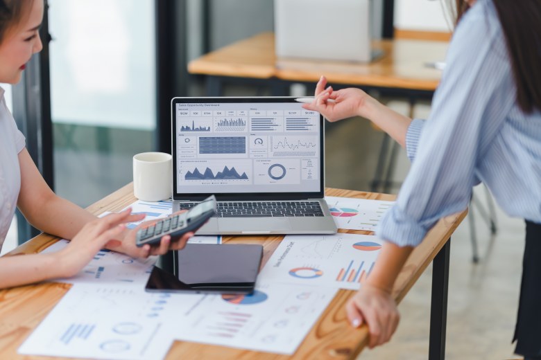 Professional analyzing financial data graphs, charts on laptop display at a modern workspace. Financial analysis or business evaluation for an easy approval startup business loan