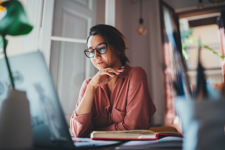 woman reading off her laptop how to overcome shiny object syndrome